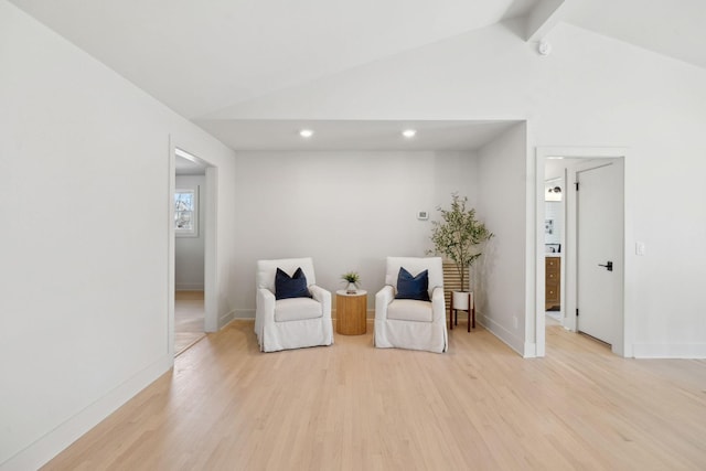 living area with vaulted ceiling with beams, light wood-style flooring, and baseboards