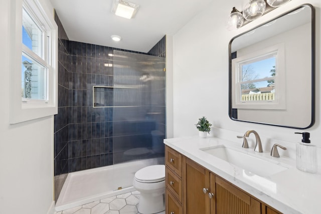 bathroom with plenty of natural light, a tile shower, and toilet