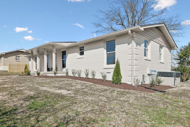 view of front facade with a porch, brick siding, and a front lawn