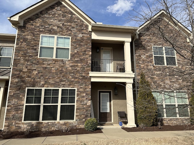 view of front of house with a balcony and stone siding