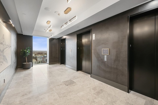 hallway with brick wall, floor to ceiling windows, and elevator