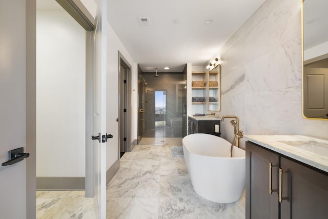 full bathroom with marble finish floor, visible vents, a shower stall, vanity, and a freestanding tub