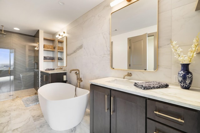 full bathroom with vanity, tile walls, a freestanding bath, marble finish floor, and a shower stall