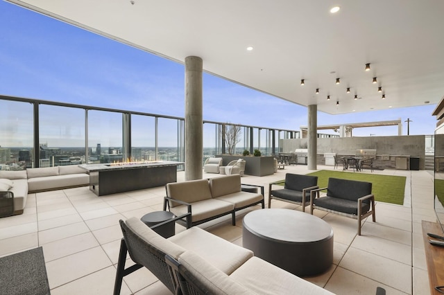 view of patio / terrace featuring a view of city and an outdoor living space with a fire pit