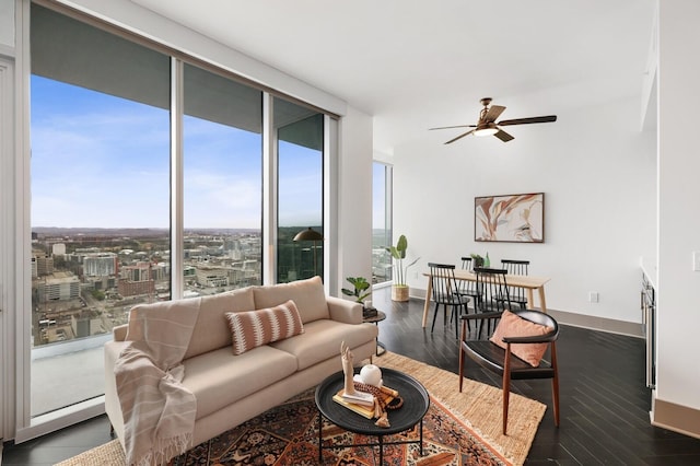 living area featuring baseboards, dark wood-style floors, a ceiling fan, and floor to ceiling windows