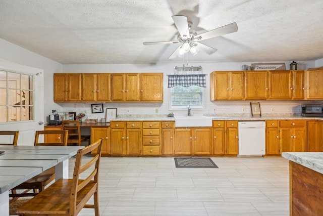 kitchen featuring a sink, black microwave, brown cabinets, and dishwasher