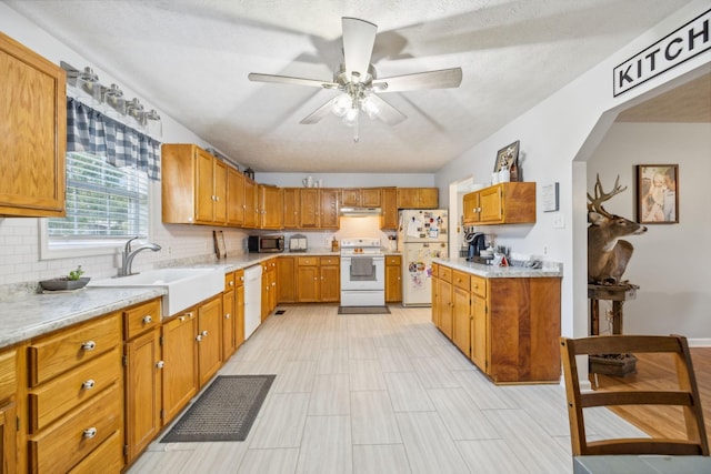 kitchen with white appliances, a sink, light countertops, under cabinet range hood, and backsplash