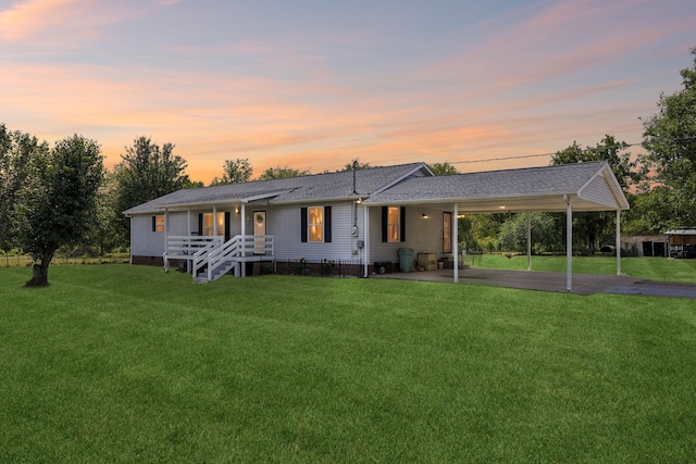 view of front of house with driveway, an attached carport, a lawn, and crawl space