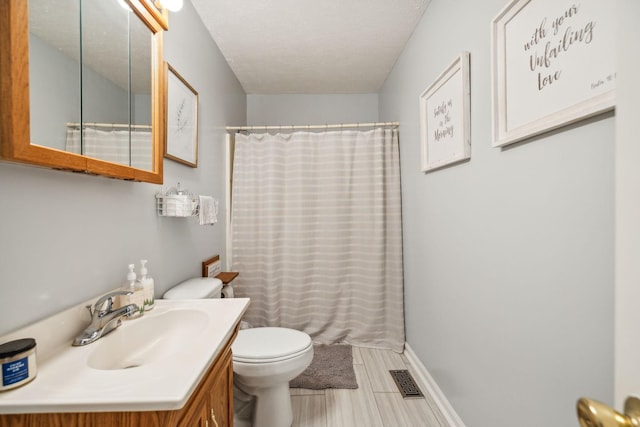 bathroom with baseboards, visible vents, toilet, a shower with curtain, and vanity