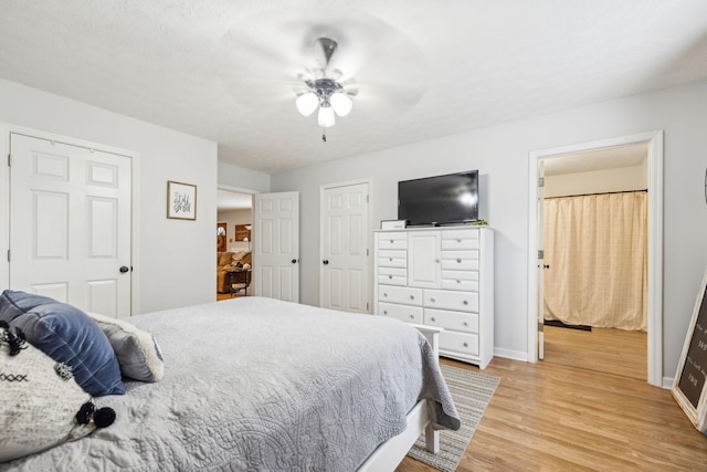 bedroom featuring a ceiling fan, light wood-style flooring, and baseboards