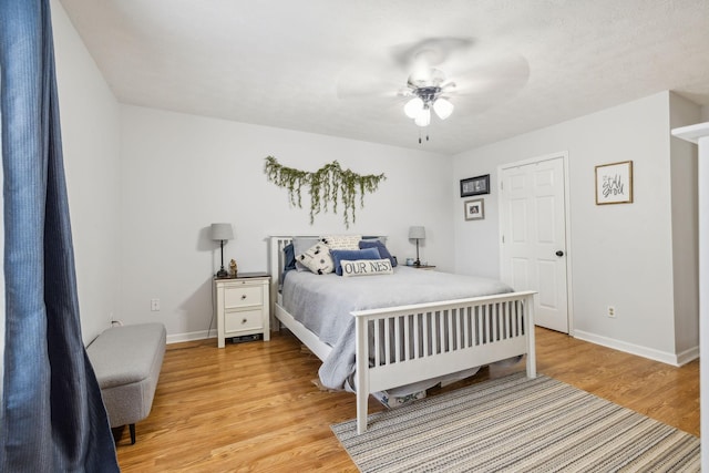 bedroom with baseboards, ceiling fan, and light wood-style floors