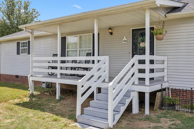 doorway to property with covered porch, a shingled roof, and crawl space