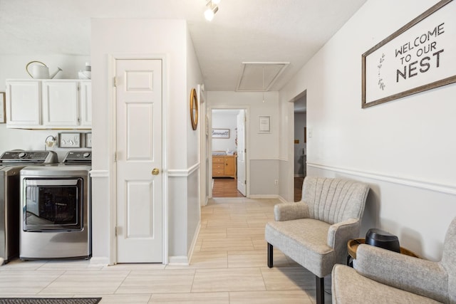 interior space featuring attic access, baseboards, cabinet space, and washing machine and clothes dryer