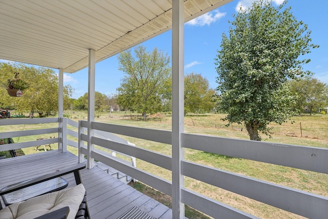 wooden deck with a rural view and a yard