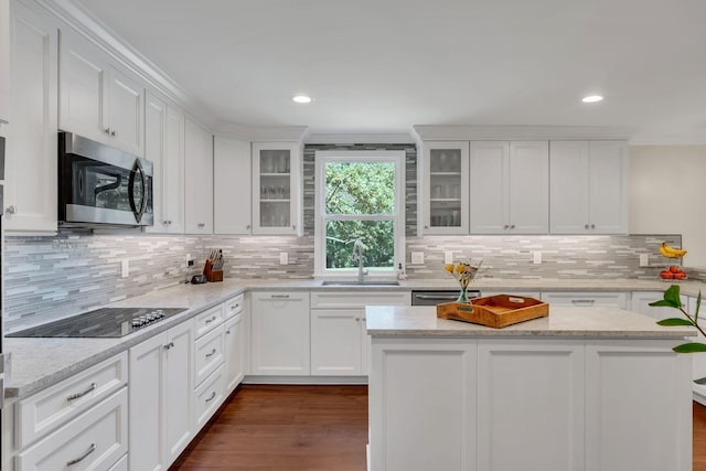 kitchen featuring black electric cooktop, a sink, white cabinetry, stainless steel microwave, and dark wood finished floors