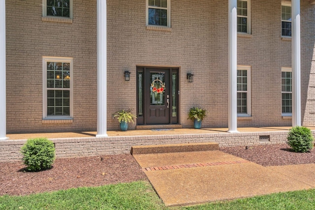 view of exterior entry with brick siding