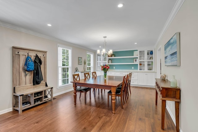 dining space with a chandelier, hardwood / wood-style floors, and ornamental molding