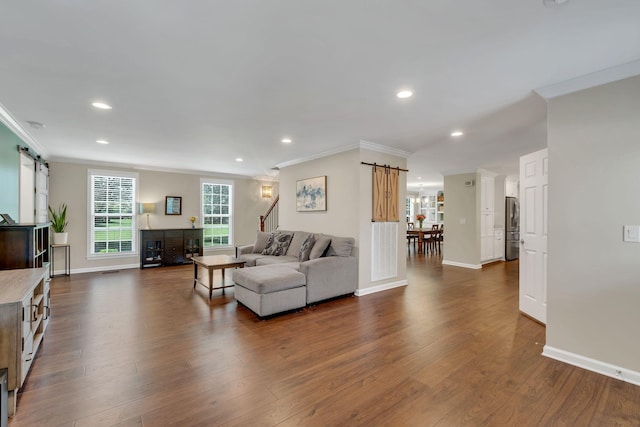 living area with dark wood-type flooring, recessed lighting, crown molding, and a barn door