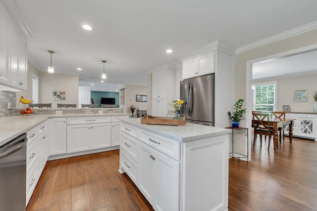 kitchen with appliances with stainless steel finishes, dark wood finished floors, ornamental molding, and backsplash