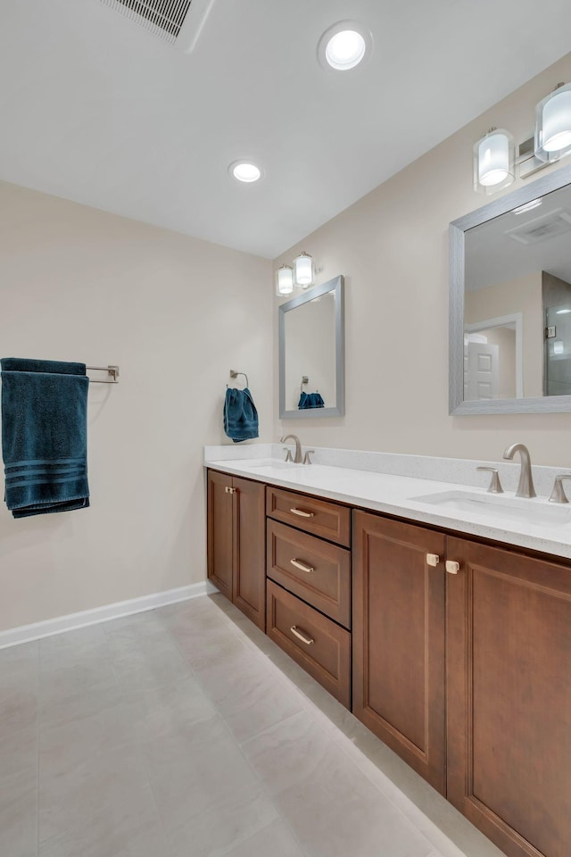 bathroom with visible vents, a sink, baseboards, and double vanity