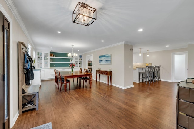 dining room featuring recessed lighting, ornamental molding, dark wood-type flooring, a chandelier, and baseboards