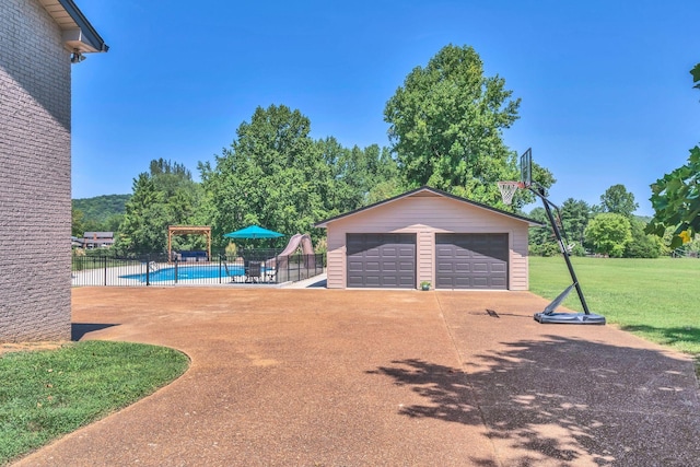 detached garage with fence and a fenced in pool