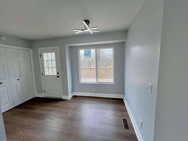 entryway with dark wood finished floors, visible vents, and a healthy amount of sunlight