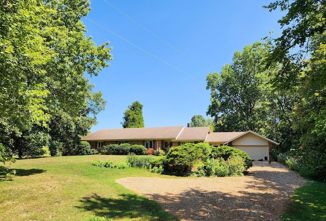 single story home featuring driveway, an attached garage, and a front yard