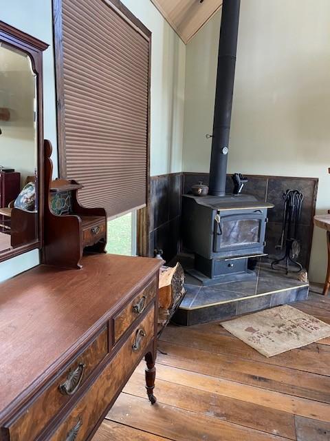 interior details with a wood stove and wood finished floors