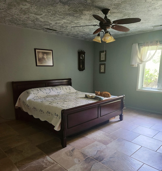 bedroom featuring a textured ceiling, baseboards, visible vents, and a ceiling fan