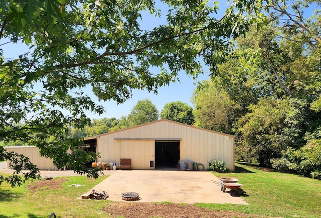 view of pole building with a yard and a fire pit