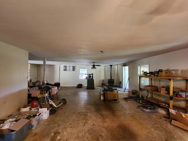 below grade area featuring a wood stove and a textured ceiling