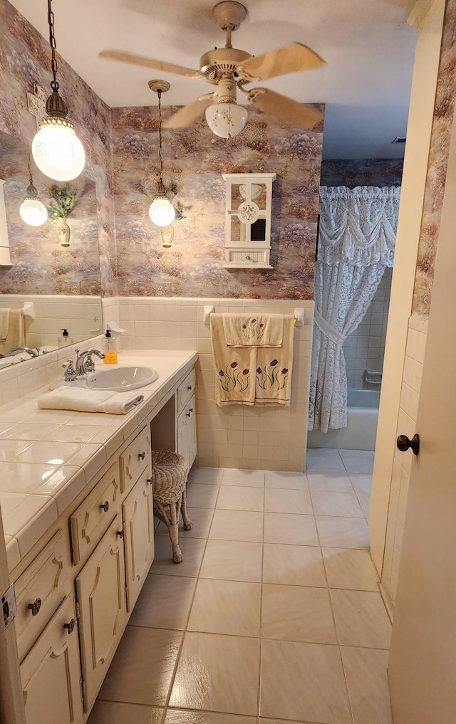 full bathroom featuring shower / bath combination with curtain, a ceiling fan, vanity, tile patterned flooring, and wallpapered walls