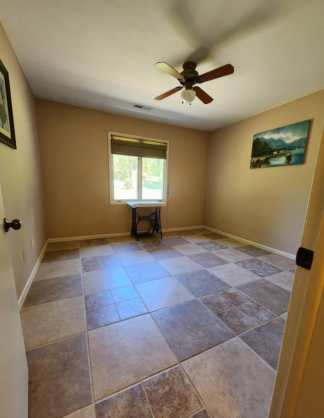 spare room featuring baseboards, visible vents, and a ceiling fan