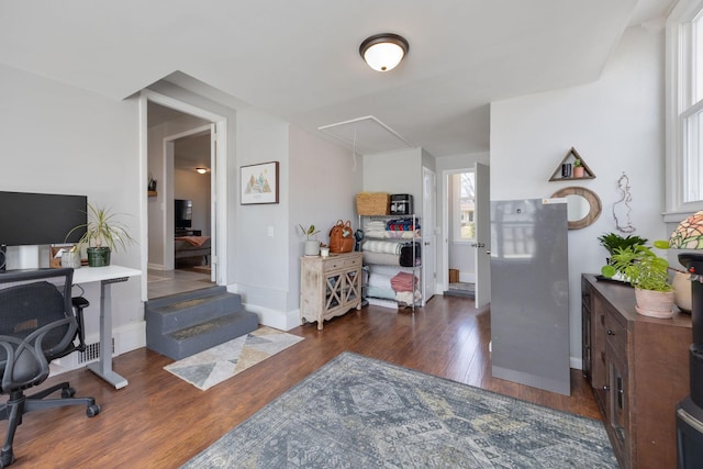 office space featuring baseboards, attic access, and wood finished floors