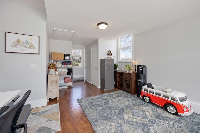 interior space featuring hardwood / wood-style floors, attic access, and baseboards