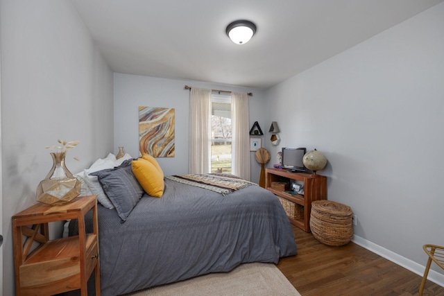 bedroom with baseboards and wood finished floors