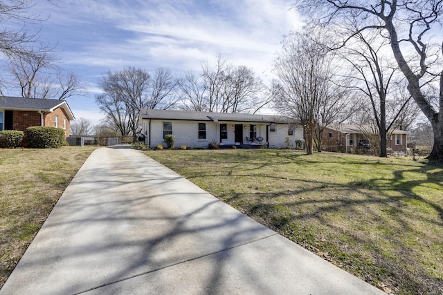 view of front facade featuring brick siding, covered porch, driveway, and a front yard