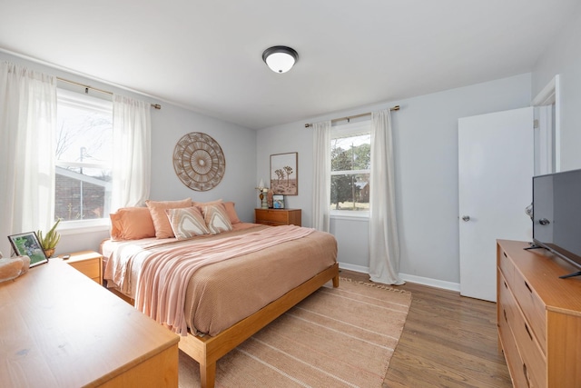 bedroom featuring baseboards and light wood finished floors