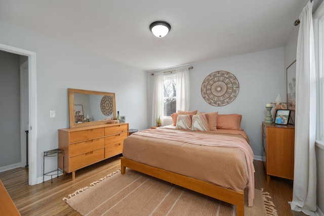 bedroom with light wood-type flooring and baseboards