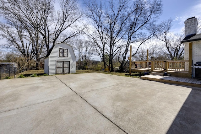 view of patio featuring a wooden deck, a storage shed, and an outdoor structure