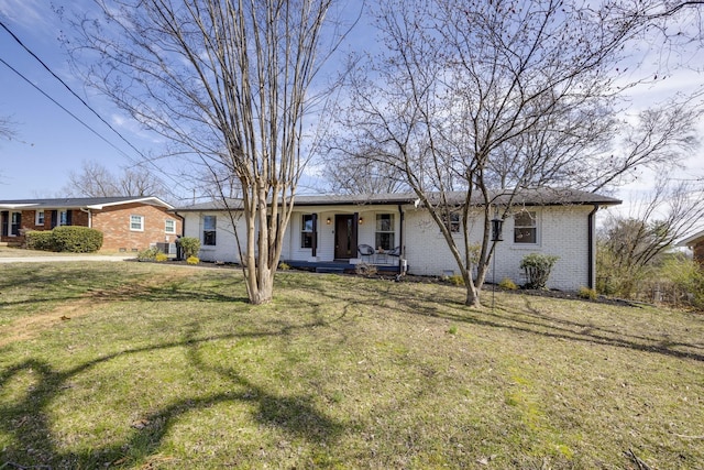 ranch-style home featuring a front yard, covered porch, and brick siding