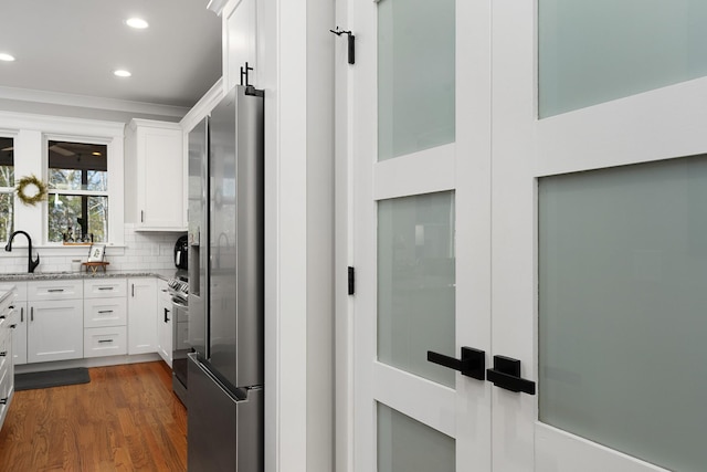 8858 Silver Maple Dr, Ooltewah, TN 37363 - kitchen featuring light stone countertops, white cabinetry, stainless steel refrigerator with ice dispenser, decorative backsplash, and dark wood finished floors