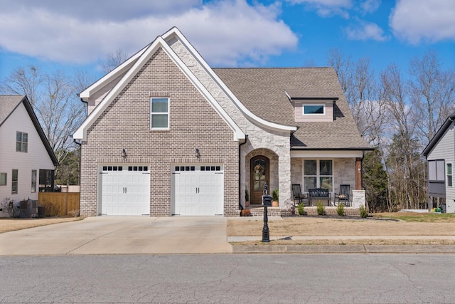 8858 Silver Maple Dr, Ooltewah, TN 37363 - view of front of house featuring brick siding, roof with shingles, a porch, concrete driveway, and stone siding