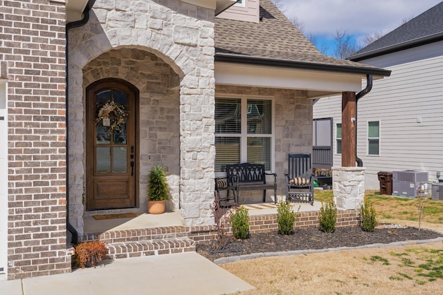 8858 Silver Maple Dr, Ooltewah, TN 37363 - property entrance with brick siding, a porch, central AC, and roof with shingles