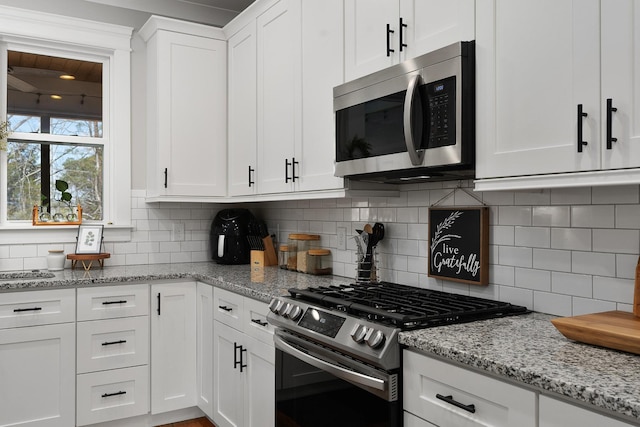 8858 Silver Maple Dr, Ooltewah, TN 37363 - kitchen with stainless steel appliances, backsplash, light stone countertops, and white cabinets