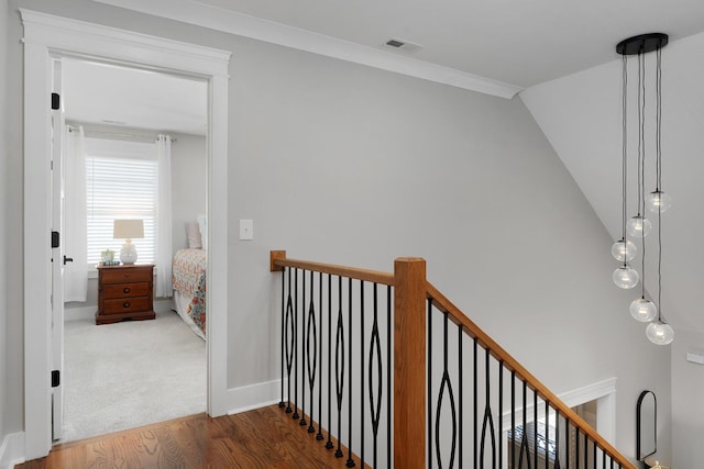 8858 Silver Maple Dr, Ooltewah, TN 37363 - hallway featuring baseboards, visible vents, ornamental molding, wood finished floors, and an upstairs landing