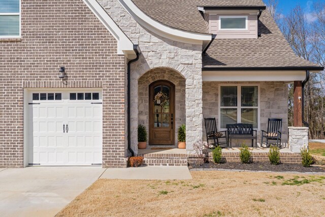8858 Silver Maple Dr, Ooltewah, TN 37363 - view of front of home with covered porch, stone siding, roof with shingles, and concrete driveway