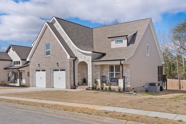 8858 Silver Maple Dr, Ooltewah, TN 37363 - view of front of property featuring a porch, a garage, cooling unit, stone siding, and driveway