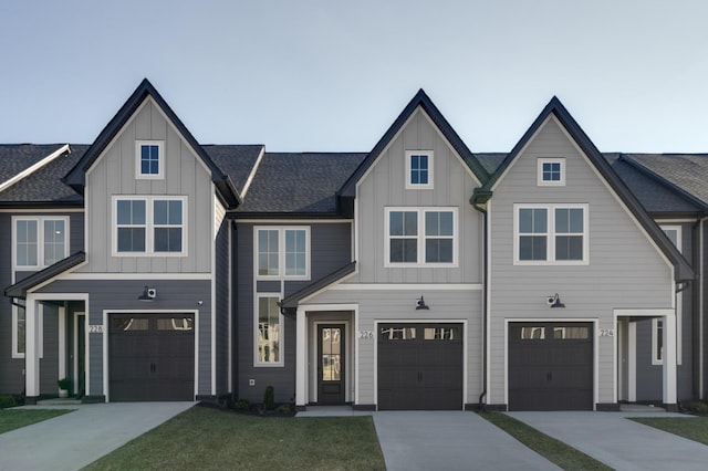 view of front of house featuring board and batten siding, concrete driveway, a shingled roof, and a garage